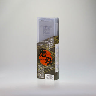 Schräge Aufsicht auf die stehende Verpackung des japanischen Schleifsteins Togi 5000, bestehend aus einer transparenten Kunststoffbox und einer bedruckten Banderole.