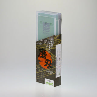 Schräge Aufsicht auf die stehende Verpackung des japanischen Schleifsteins Togi 1000, bestehend aus einer transparenten Kunststoffbox und einer bedruckten Banderole.