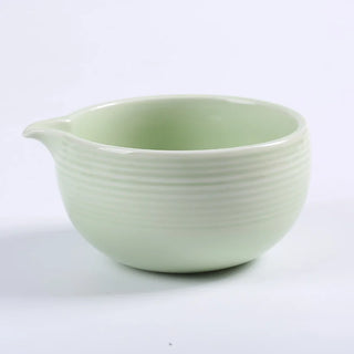 weiße matchaschale aus keramik mit tülle vor weißem hintergrund