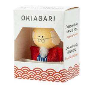 Okiagari-Figur eines Großvaters in einer eleganten Geschenkbox mit der Aufschrift „OKIAGARI“ und dem japanischen Sprichwort „Fall seven times, stand up eight“.