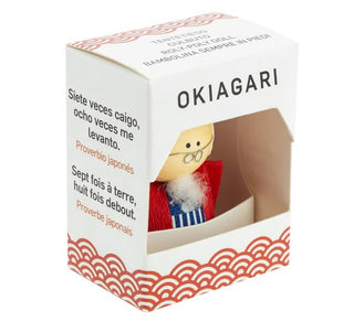 Okiagari-Figur eines Großvaters in einer dekorativen Verpackung mit mehrsprachigem Sprichwort „Siete veces caigo, ocho veces me levanto“ und „Sept fois à terre, huit fois debout“.