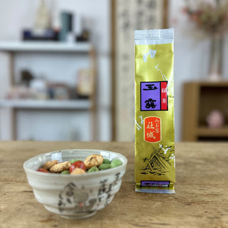 Links im Bild steht unsere Schale "Jizo", gefüllt mir japanischen Snacks. Rechts daneben steht eine Packung Gyokuro Yashiro