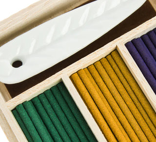 Nahaufnahme der Räucherstäbchen in drei Farben mit elegantem weißen Keramikhalter