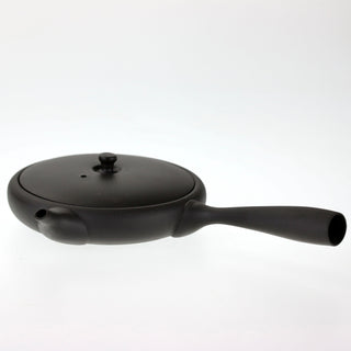 Seitenansicht der flachen, schwarzen Teekanne Hiragata Kyusu Shizuku mit geschlossenem Deckel und langem seitlichem Griff.