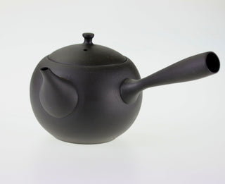 Seitenansicht der dunklen Teekanne Kyusu Iwa mit geschlossenem Deckel und seitlichem Griff.
