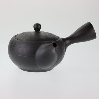 Seitenansicht der dunkelbraunen, horizontal strukturierten Teekanne Kyusu Nachi mit geschlossenem Deckel und seitlichem Griff.