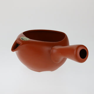 Schräge Aufsicht auf die orangefarbene Teekanne Kyusu Kinkan ohne Deckel mit Ausguss und seitlichem Griff.
