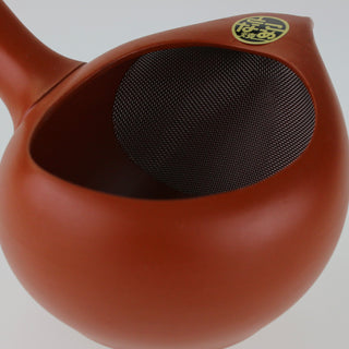 Detailaufnahme der orangefarbenen Teekanne Kyusu Kinkan, die das Innere mit dem großen, flachen Korbsieb zeigt.