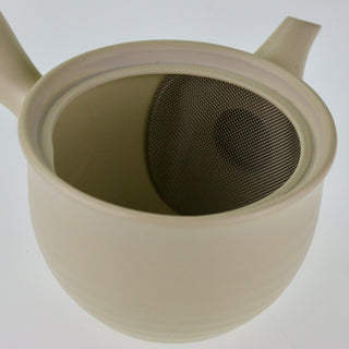 Detailaufnahme der geöffneten elfenbeinfarbenen Teekanne Kyusu Mayu, die das Innere mit dem integrierten Sieb zeigt.