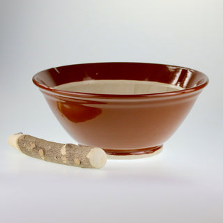 Schräge Aufsicht auf den braunen japanischen Keramik-Mörser Suribachi mit einem daneben liegenden hölzernen Stößel.