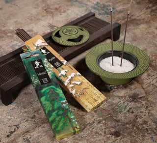 Koh-Do Kyoto und Koh-Do Hinoki Räucherstäbchen in dekorativer Umgebung mit Räucherschale und brennenden Stäbchen.