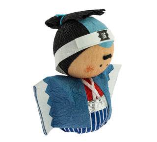 Seitenansicht der Okiagari-Figur "Shinsengumi, der Krieger" mit blauer Uniform, rotem Gürtel und weißem Stirnband mit japanischen Schriftzeichen.