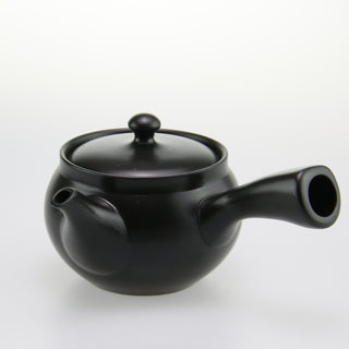 Die schwarze Kyusu-Teekanne "Kage" aus Keramik mit rundem Deckel und seitlichem Ausguss. Die Teekanne hat eine glatte Oberfläche und steht vor einem weißen, neutralen Hintergrund.