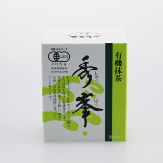 Eine quadratische Packung Bio-Matcha Shuhou, in den Farben weiß, schwarz und grün, mit einer japanischen Kalligraphie auf dem Etikett