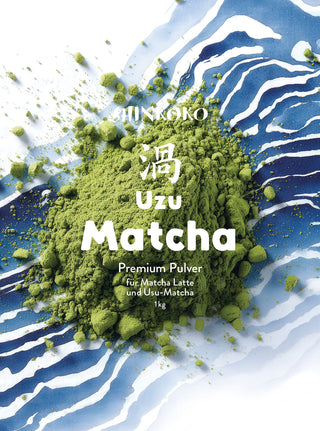 Draufsicht auf leuchtend grünes Matcha-Pulver, das auf einem blau-weißen Wellenmuster verstreut ist, versehen mit dem weißen Text „SHINKOKO Uzu Matcha Premium Pulver 1kg“ und japanischen Schriftzeichen.