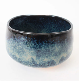 Handgefertigte Matcha-Schale Kuroshio mit schwarzer Glasur, tiefblauen Verläufen und hellen weißlichen Flächen.